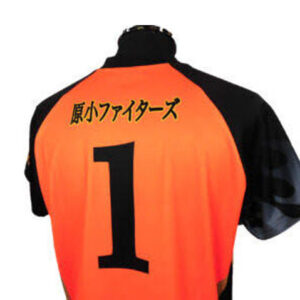 Back of an orange sports jersey with black sleeves, featuring a large number 1 and Japanese text on the upper back.