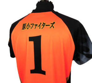 Back view of an orange sports jersey with a large black number 1 and Japanese characters across the upper back.