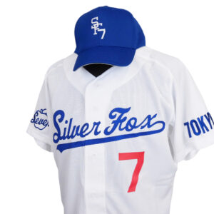 White athletic jersey on a mannequin, featuring blue script reading 'Silver Fox' and a large red number 7; blue cap with a white logo.