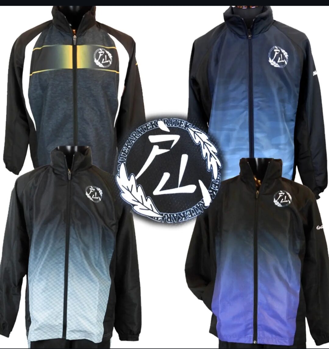 Four black zip-up jackets with gradient blue/gray panels and a circular logo on the left chest, arranged around a central emblem.