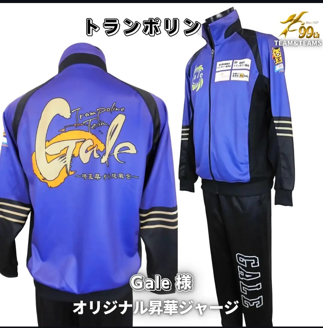 Back view of a blue and black trampoline team jacket with a large yellow 'Gale' logo and 'Trampoline Team' text on the back, striped cuffs on the sleeves.